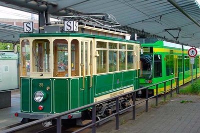 Die historische Straßenbahn im Vordergrund mit einer modernen Straßenbahn der STOAG dahinter