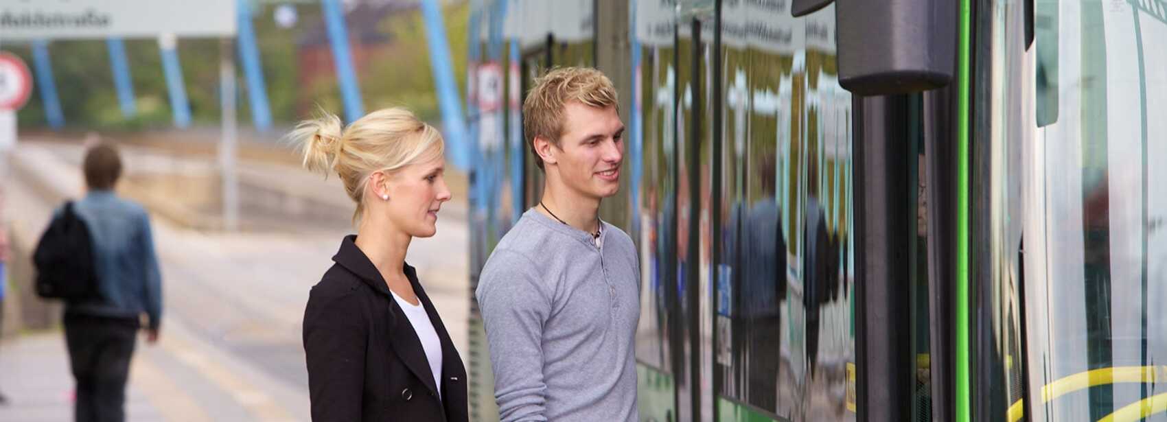 Zwei Personen steigen in den Bus