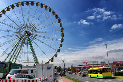 A STOAG bus drives past a fair with a ferris wheel