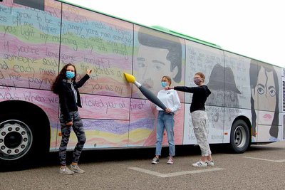 Die Gewinner des STOAG Kreativwettbewerbes stehen vor einem bedruckten Linienbus und posieren mit einem Pinsel in der Hand