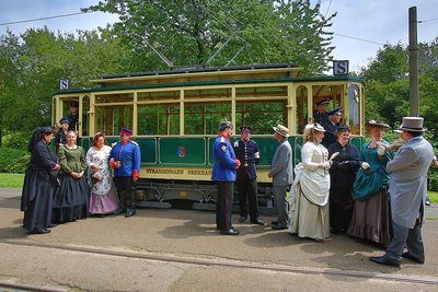 People stand in front of a historic tram