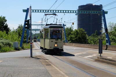 Triebwagen 888 auf der ÖPNV-Trasse, im Hintergund der Gasometer