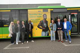 SpitzensportlerInnen aus Oberhausen vor einem Linienbus