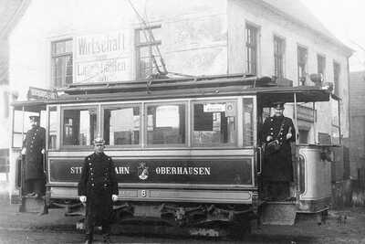 Drei Männer in alter STOAG Straßenbahn